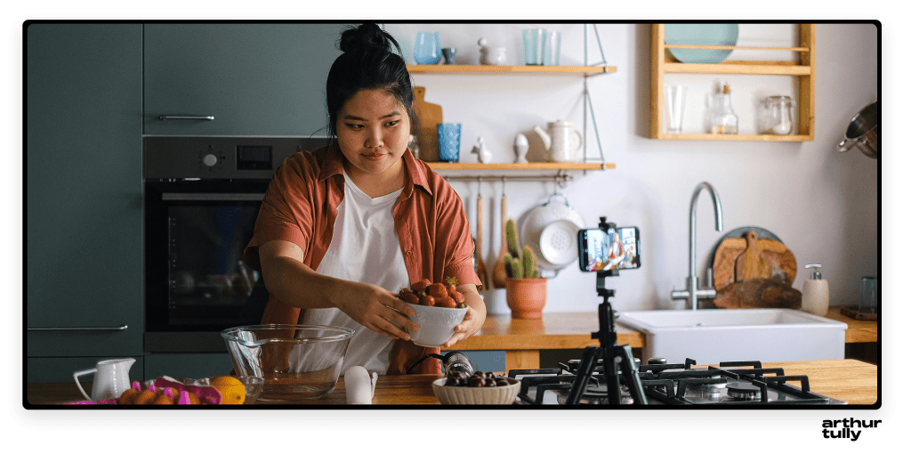 person in kitchen recording cooking video